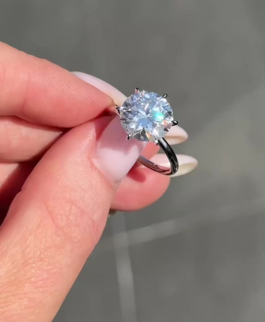 video of round solitaire moissanite, worn on hand, sparkle highlight, elegant design, close-up view | Moissanite Engagement Rings