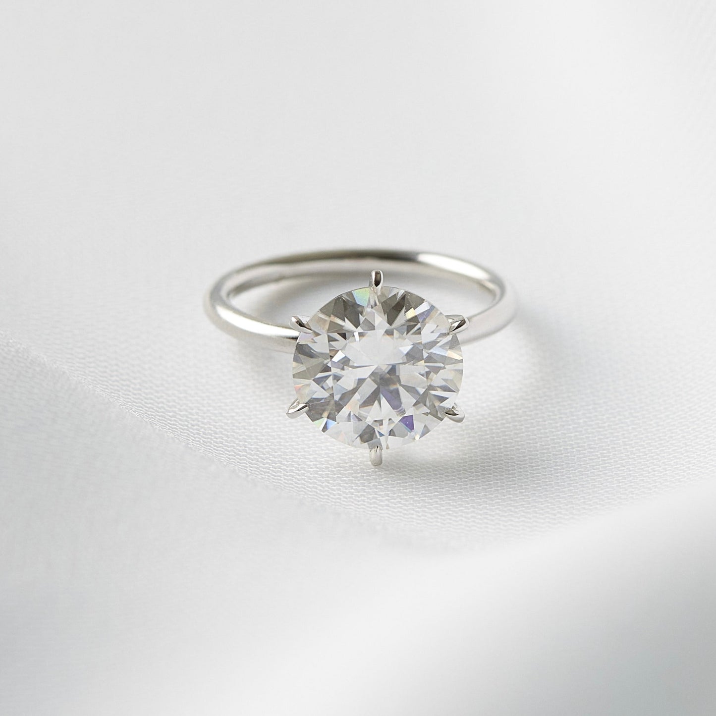 Round-cut engagement ring by Moissanite Engagement Rings, showcasing a brilliant round moissanite stone in an elegant and timeless design.