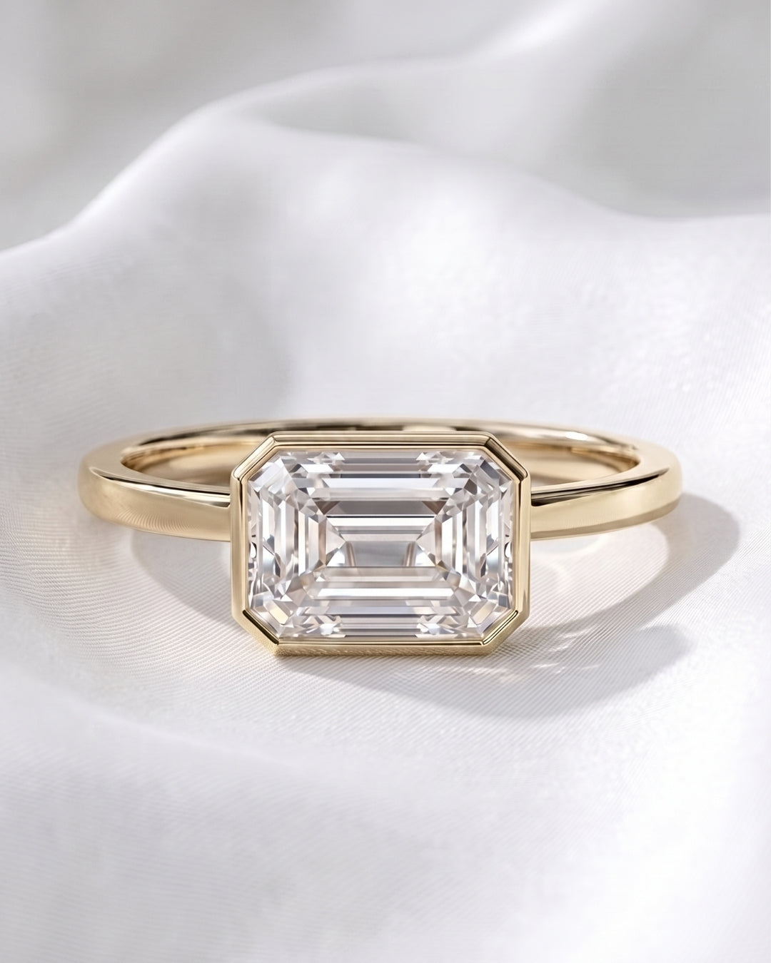 Sadie: East West Bezel Emerald Solitaire Moissanite Engagement Ring