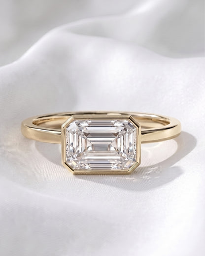 Sadie: East West Bezel Emerald Solitaire Moissanite Engagement Ring
