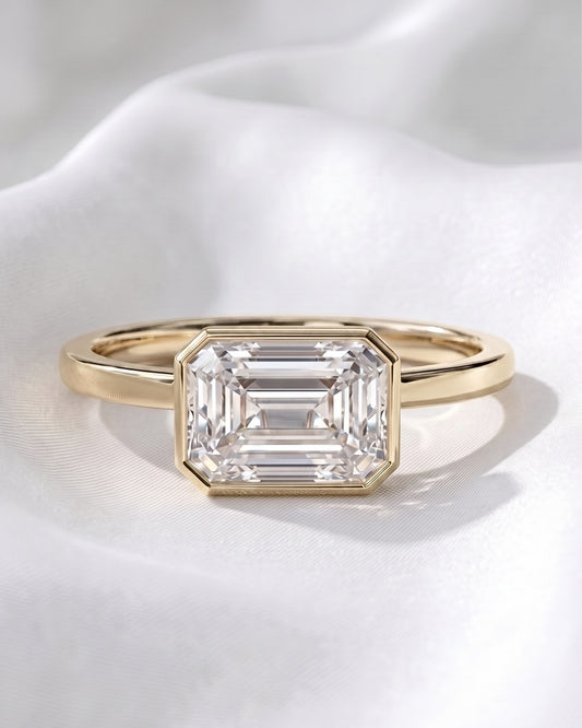 Sadie: East West Bezel Emerald Solitaire Moissanite Engagement Ring
