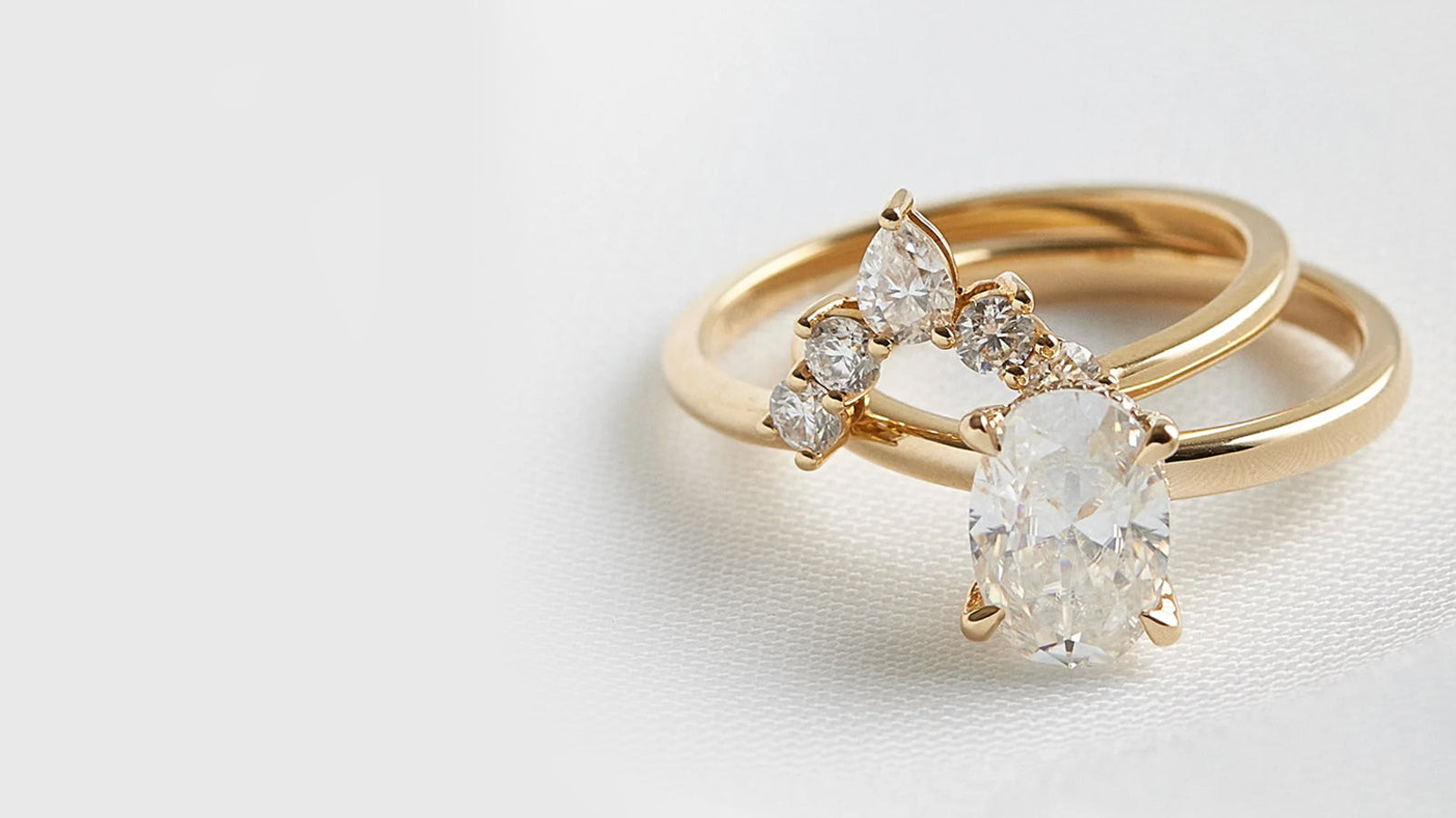 Gold ring with a oval-shaped diamond on white background

