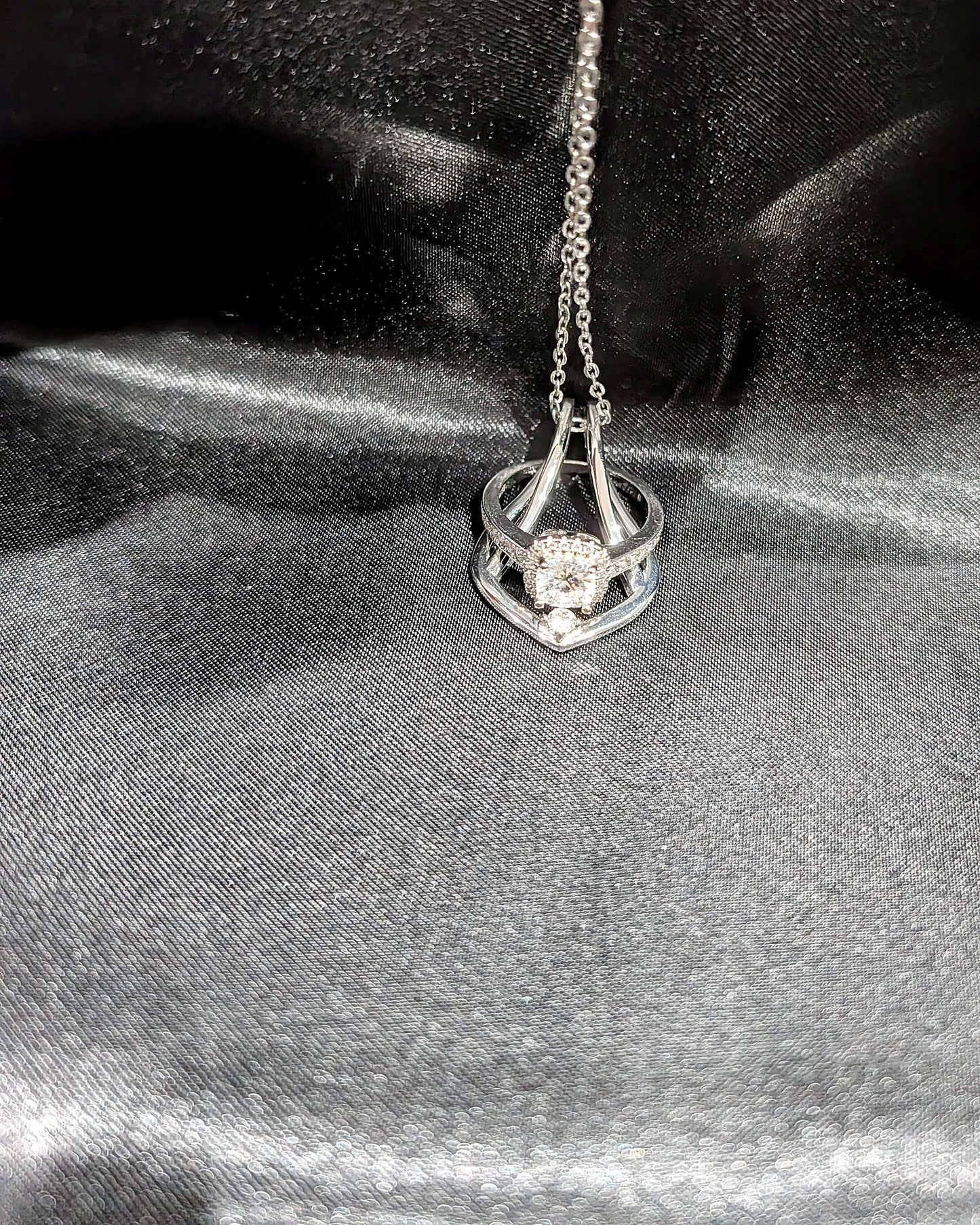 Silver Ring Holder Necklace holding a halo engagement ring