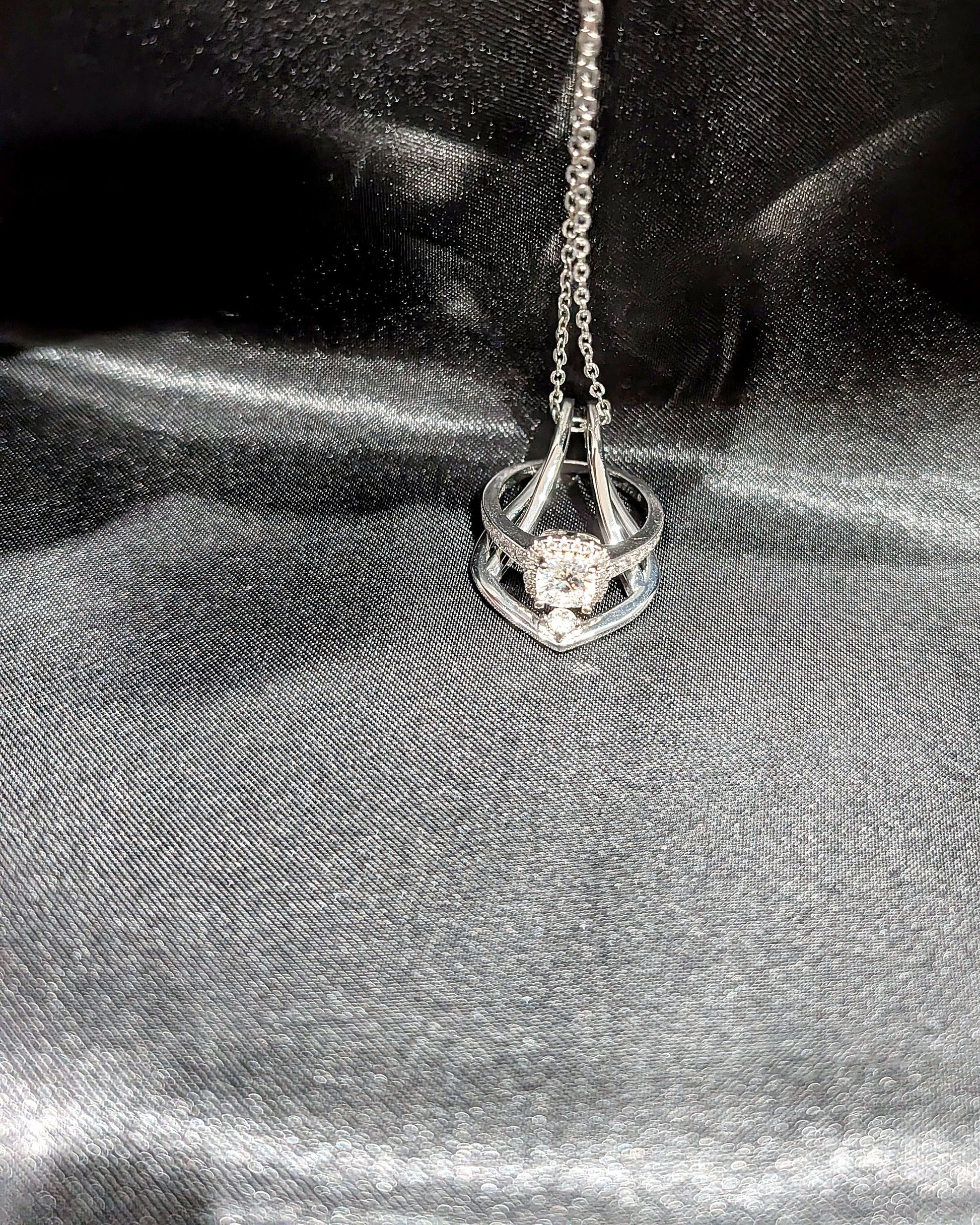 Silver Ring Holder Necklace holding a halo engagement ring